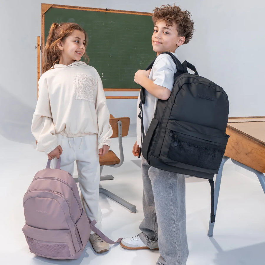Enfants avec sacs d’école Trippin Store dans une cour d’école